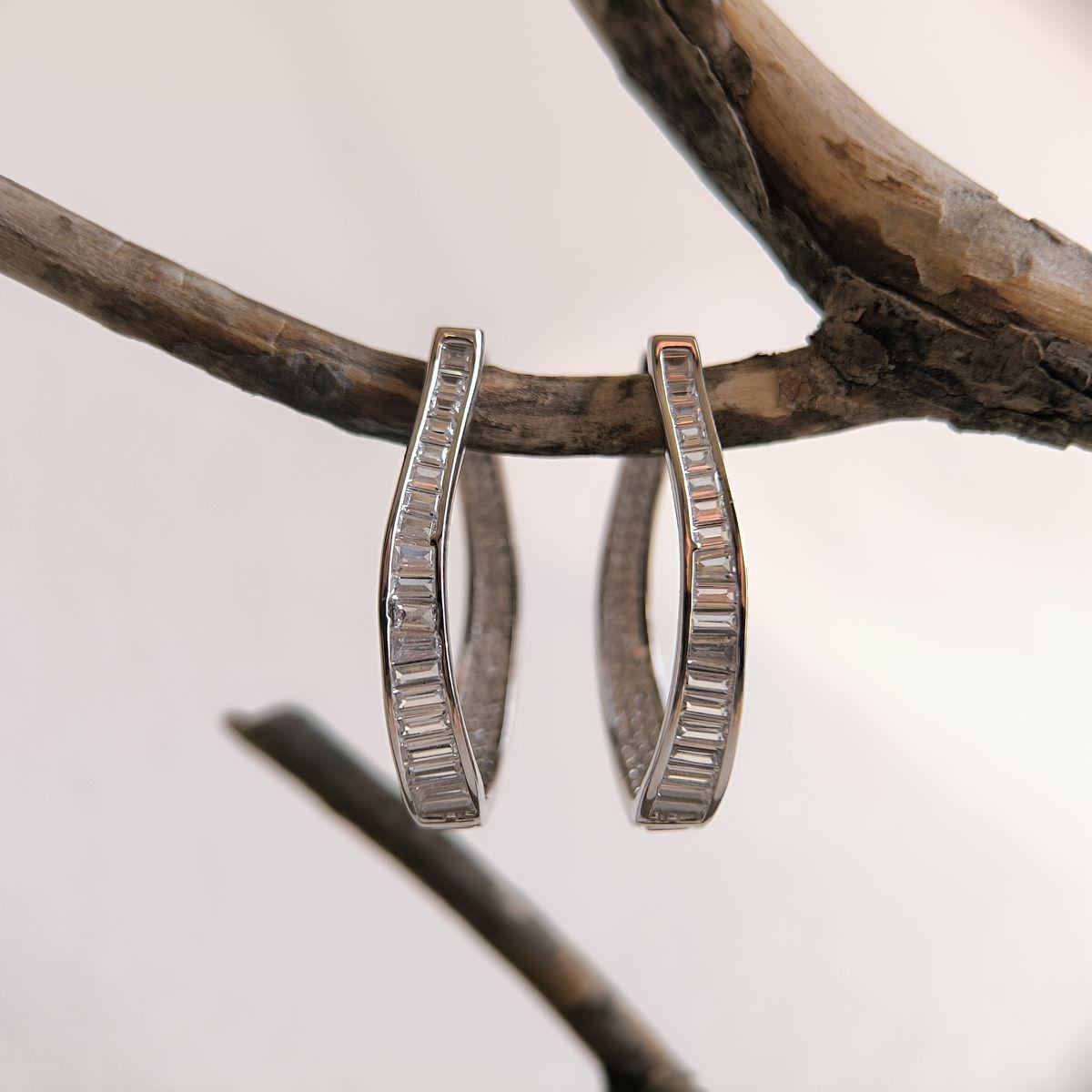 Срібні сережки-кільця вигнутої форми з фіанітами багетної огранки Срібні сережки-кільця вигнутої форми з фіанітами багетної огранки