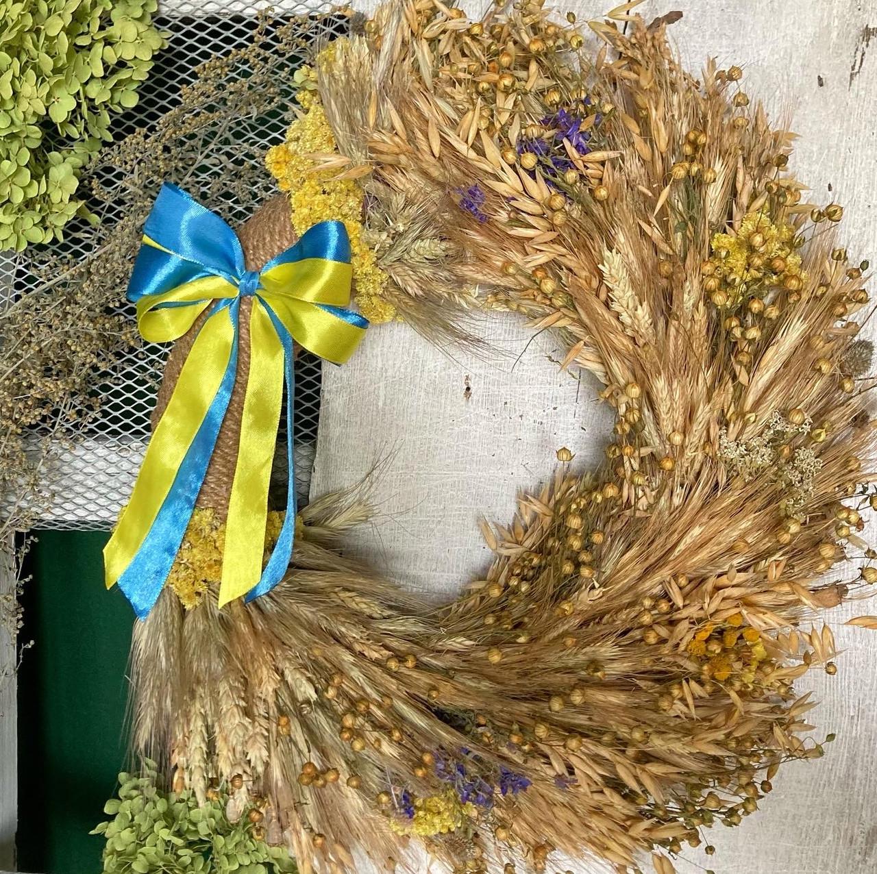 Декоративный настенный интерьерный веночек из колосков и сухоцветов с сине-желтым бантом 35 см (1694195043)