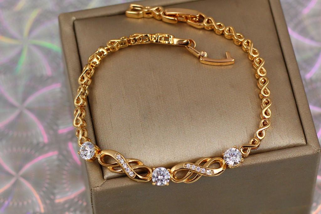 Браслет Xuping Jewelry восьмерки с тремя круглыми белыми камнями в центре 19 см 6 мм. Золотистый