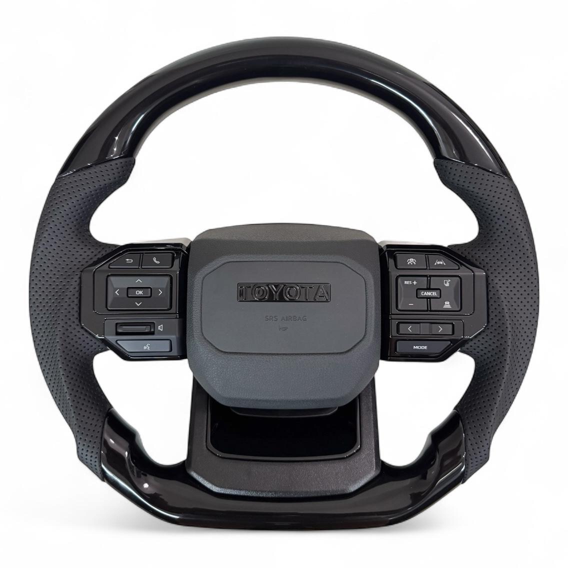 Руль для Toyota Land Cruiser 100/Prado 120 в сборе в стиле LC250 рояльный лак со скошенным низом логотип черный глянец (29172368)
