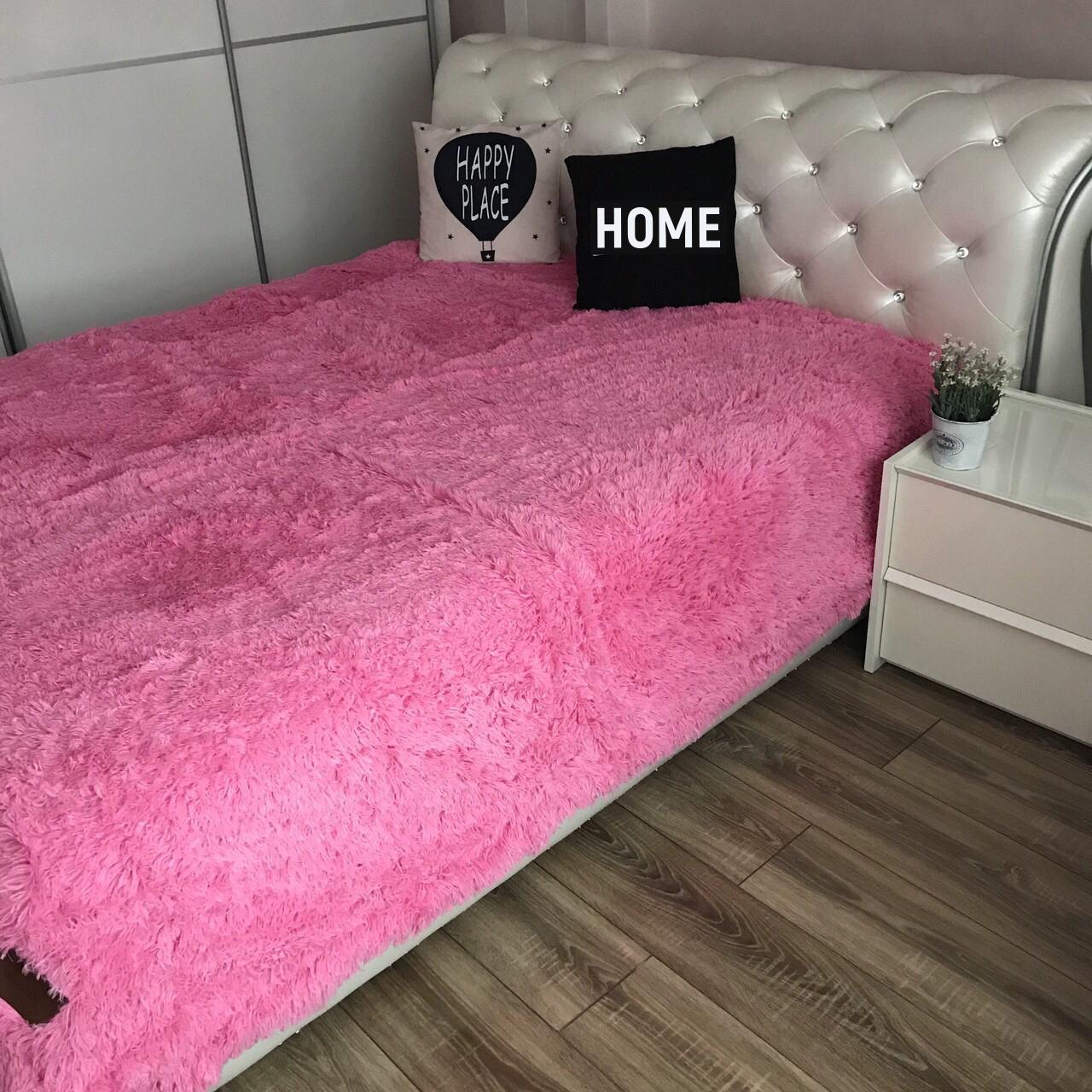 Розовый плед на диване