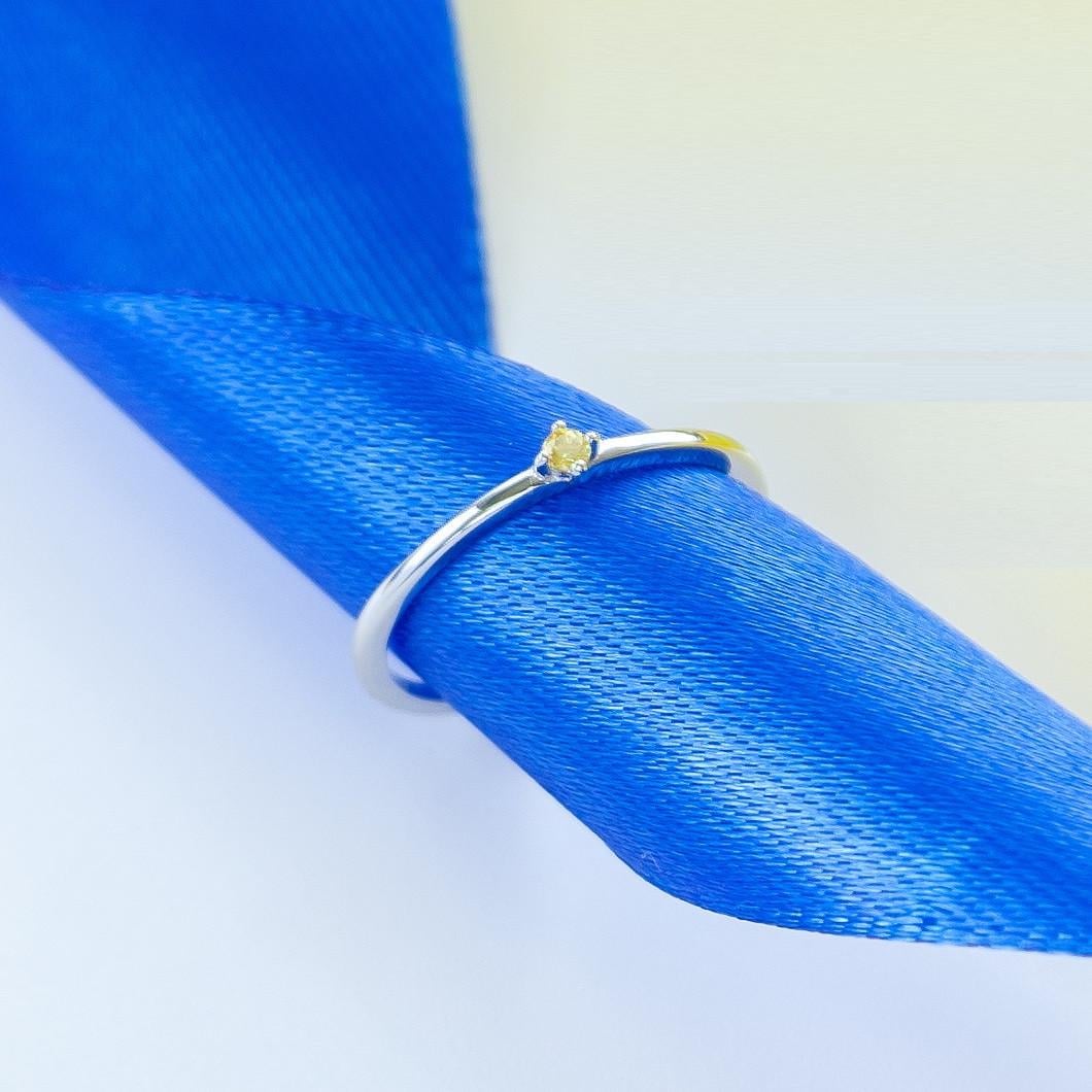 Кольцо серебряное с тонкой оправой дополнено желтым камнем р. 18